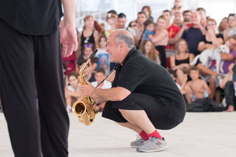 David Dorfman squats low with his saxophone
